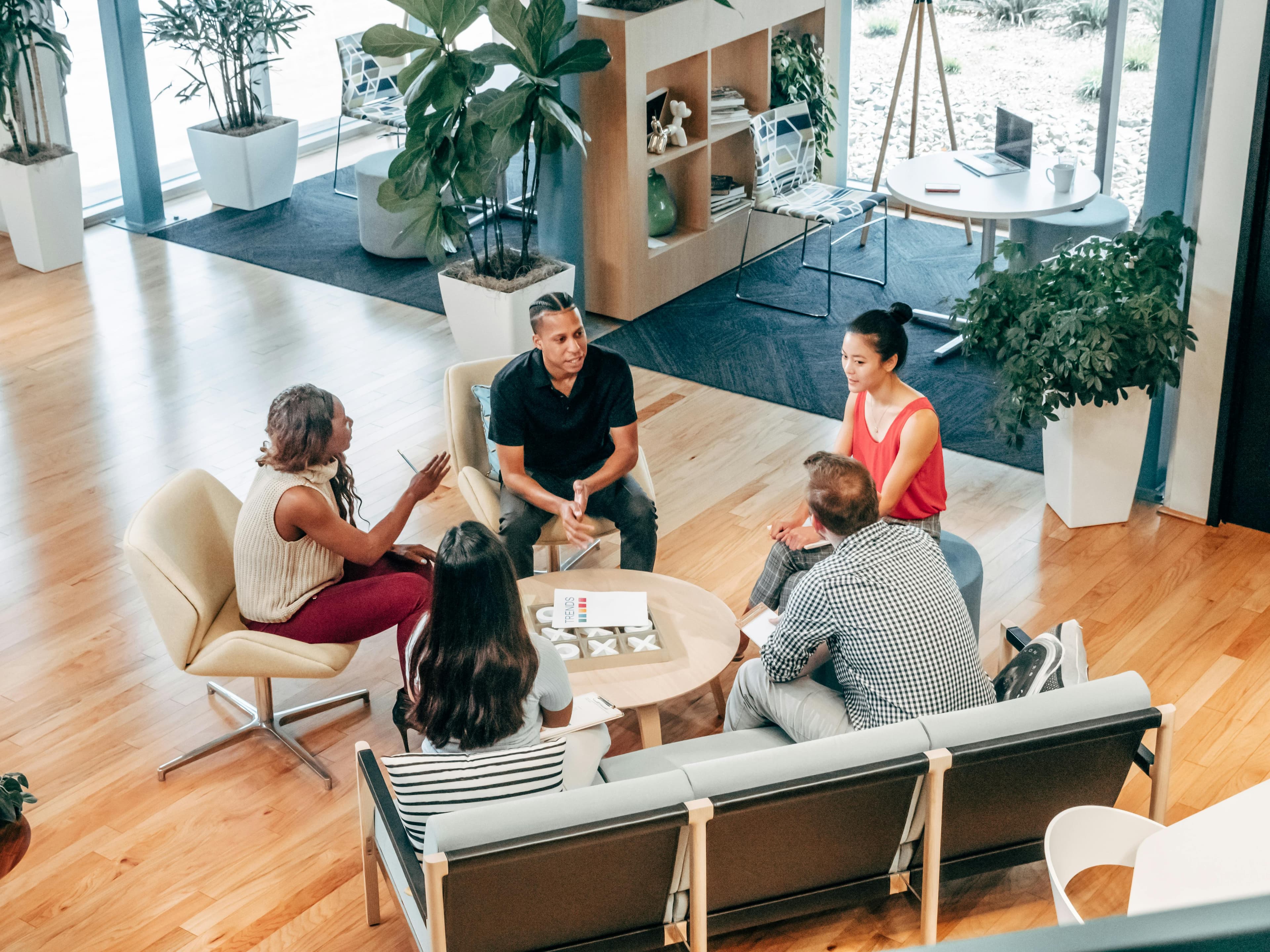 A small business team gathered in a sunlit lounge, working through readiness questions together